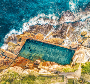 Luftaufnahme eines natürlichen Meerespools zwischen Felsen an der Südküste Australiens mit türkisblauem Wasser.