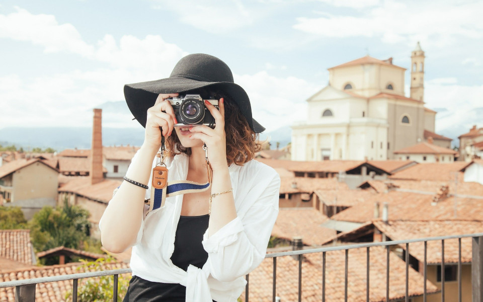 Frau mit Hut und Kamera