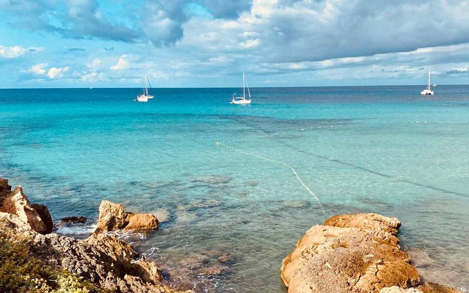 Strand mit Felsen und Segelschiffen