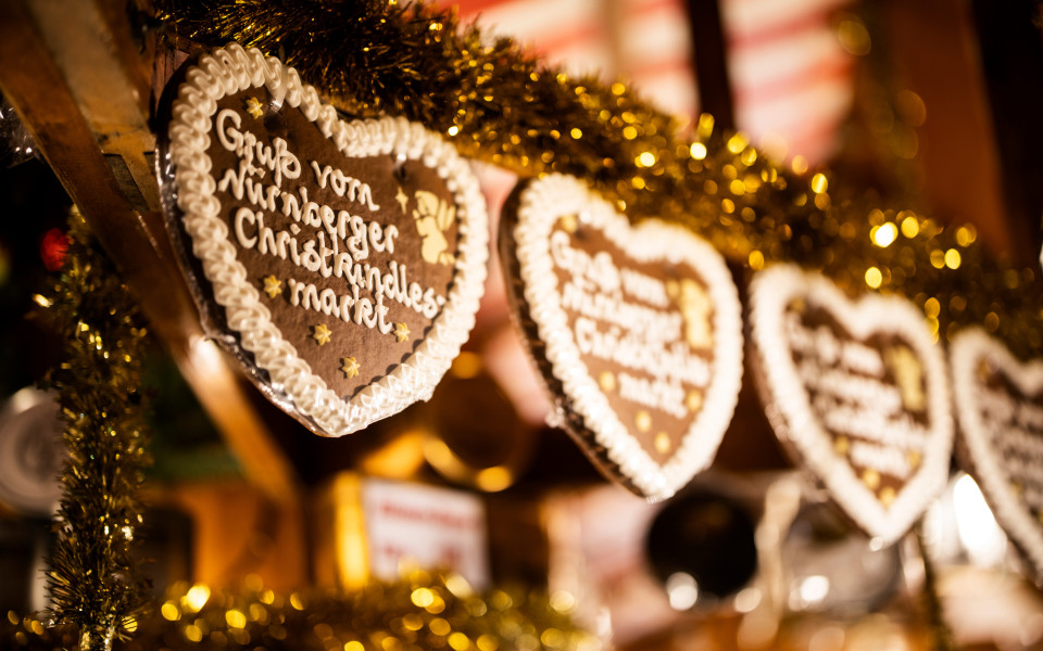 Lebkuchenherzen mit Aufschrift ‚Gruß vom Nürnberger Christkindlesmarkt‘ an Weihnachtsmarktstand in Nürnberg